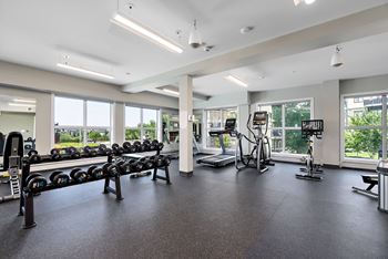 A gym with a variety of equipment including treadmills, weights, and exercise bikes.